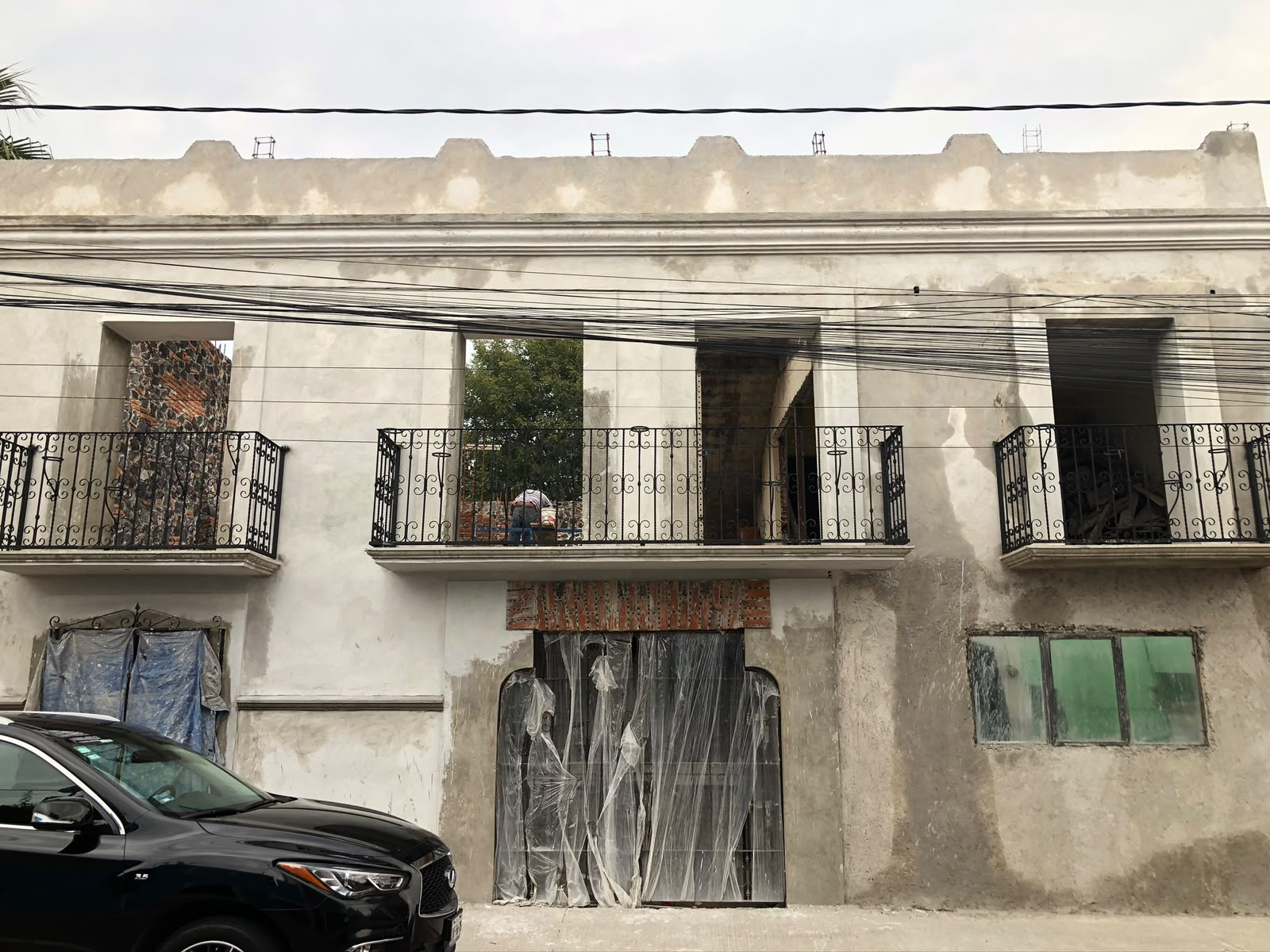 Fachada en obra gris con balcones de herrería