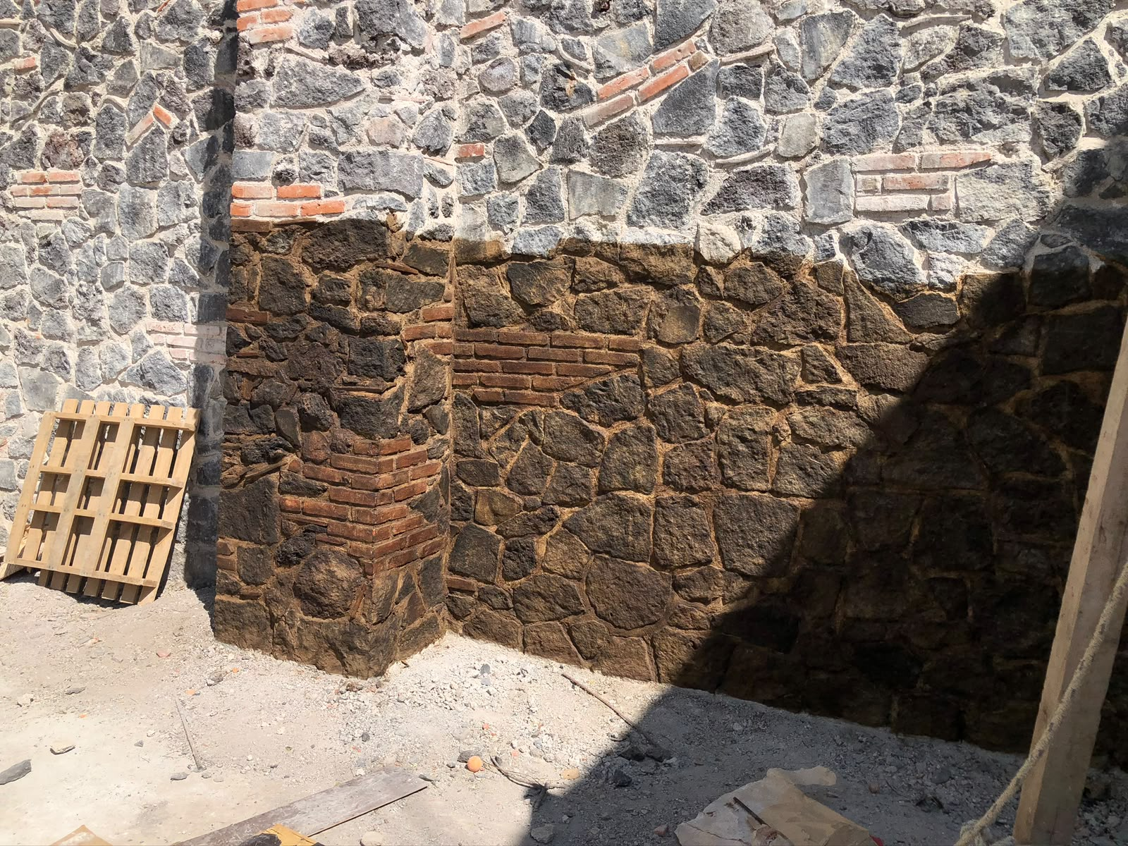 Muro de piedra volcánica y ladrillo